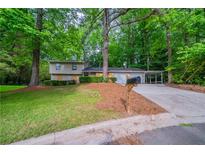Charming home with a well-maintained front yard, covered parking, and mature trees at 5810 Tree Line Ter, Lithonia, GA 30058