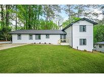 Newly renovated home with fresh white paint, contrasting black trim, and bright green lawn at 2813 Hillside Rd, Smyrna, GA 30080