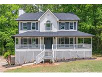 Charming two-story home with a large covered porch and inviting curb appeal at 5139 Coolamber Dr, Powder Springs, GA 30127