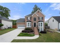 Charming two-story brick home with a well-manicured front lawn and attached two car garage at 1130 Lochshyre Way, Lawrenceville, GA 30043
