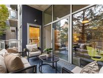 A cozy balcony with comfortable seating, a glass-topped table, and views of the surrounding greenery and bedroom inside at 130 Arizona Ne Ave # 104, Atlanta, GA 30307