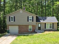 Charming home with a well-maintained lawn, neutral-colored siding, and a brick facade on the lower level at 3832 Natalie Way, Ellenwood, GA 30294