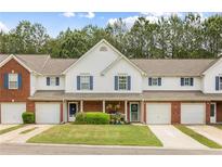 Charming townhome with a well-manicured lawn and colorful landscaping adding to its curb appeal at 268 Cottonwood Creek Cir, Canton, GA 30114