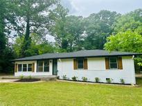 Charming single-story home with white brick, dark roof, and well-manicured lawn at 2011 W Starmount Way, Decatur, GA 30032