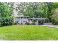 Charming two-story home featuring a well-manicured lawn and a convenient carport at 5795 Deerfield Trl, Atlanta, GA 30349