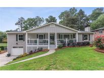 Charming brick home with a welcoming front porch, beautiful landscaping, and an attached single car garage at 185 Pamela Nw St, Marietta, GA 30064