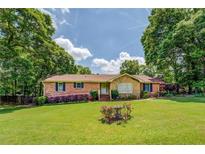 Charming brick home with lush green lawn, beautiful landscaping, and inviting curb appeal at 1850 Francis Sw Rd, Conyers, GA 30094