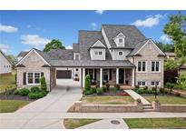 Beautiful brick home featuring manicured landscaping, a covered porch, and a driveway leading to the garage at 487 Carmichael Cir, Canton, GA 30115