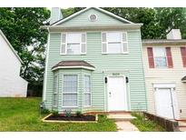 Charming two-story home featuring light green siding, white trim, and a bay window at 5624 Stonington Trace Pkwy, Stone Mountain, GA 30087