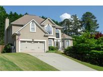 Charming two-story home with a well-manicured lawn, a two-car garage, and lush landscaping at 3606 Packhorse Run, Marietta, GA 30066