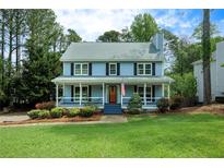 Charming two-story home with a welcoming front porch and lush green lawn at 4994 Willow Creek Dr, Woodstock, GA 30188