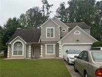Charming two-story home featuring a well-manicured lawn, neutral stucco, and an attached two-car garage at 3393 Chancellors Dr, Powder Springs, GA 30127