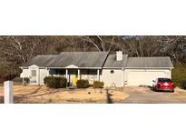Charming single-story home featuring a well-maintained lawn and attached two car garage at 497 Natasha Dr, Auburn, GA 30011