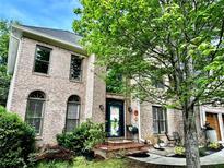 Charming two-story brick home featuring arched windows and a beautifully landscaped front yard, exuding curb appeal at 5105 Tynewick Ne Trce, Roswell, GA 30075
