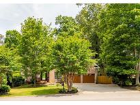 Charming brick home with a well-manicured lawn, mature trees, and a two-car garage at 5105 Tynewick Ne Trce, Roswell, GA 30075
