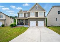 Two-story home featuring a well-manicured lawn and a two-car garage at 7698 Hansel Ln, Lithonia, GA 30058