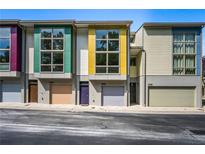 Modern townhome with colorful exterior, large windows, and individual garages at 1360 Peter Haughton Nw Way, Atlanta, GA 30318