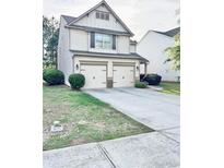 Charming two-story home featuring a two-car garage and well-maintained landscaping in a suburban neighborhood at 130 Worthing Ln, Fairburn, GA 30213