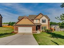Charming two-story home with a well-manicured lawn and an attached two-car garage at 609 Turnbill Dr, Mcdonough, GA 30252