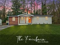 Charming single story home with lush lawn and an inviting orange front door at 904 Fairburn Nw Pl, Atlanta, GA 30331