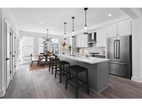 Bright kitchen features stainless steel appliances, a large island with barstool seating, and an adjacent dining area at 507 Motivation Nw Cir, Atlanta, GA 30309