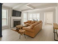 Bright living room featuring a fireplace, hardwood floors, and a comfortable brown leather sofa at 802 Lismore Se # 2, Smyrna, GA 30080