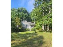 Traditional home with light siding, green lawn, and a beautiful surrounding landscape at 144 Wiley Dr, Douglasville, GA 30134