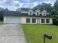 Charming two-story home with a well-maintained lawn, attached garage and long driveway at 5340 Forest Pl, Stone Mountain, GA 30088