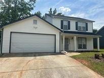 Charming two-story home features a two-car garage and a welcoming front porch with classic columns at 1247 To Lani Farm Rd, Stone Mountain, GA 30083