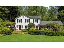 Charming two-story home with black shutters, lush landscaping, and a brick entryway, offering classic curb appeal at 45 Michelle Ne Cir, Atlanta, GA 30342
