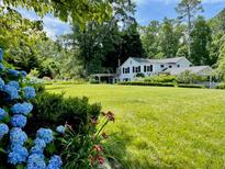 Beautiful lawn and landscaping with hydrangea bushes in front of the charming white home at 45 Michelle Ne Cir, Atlanta, GA 30342