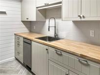 Updated kitchen with light gray cabinets, butcher block counters, stainless steel sink, and modern fixtures at 475 Mount Vernon Ne Hwy # 129C, Atlanta, GA 30328