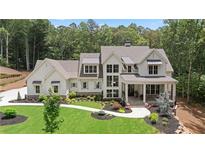 Stunning white two-story home with meticulous landscaping, stone accents, and a welcoming front porch at 1084 Wrights Mill Rd, Canton, GA 30115