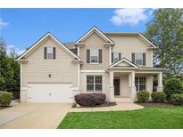 Charming two-story home featuring manicured lawn, a two-car garage, and classic architectural details at 308 Evening Rain Crst, Canton, GA 30114