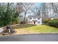 Charming two-story home with manicured lawn, and inviting red door and black shutters at 970 Winding Creek Trl, Sandy Springs, GA 30328