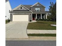 Charming two-story home featuring a gray brick facade, well-manicured lawn, and a two-car garage at 5452 Fountainhead Ln, Auburn, GA 30011