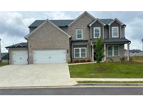 Charming two-story brick home featuring a three-car garage and landscaped front yard at 98 Longhorn Way, Auburn, GA 30011