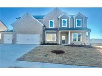 Charming two-story home with gray brick, a two-car garage, manicured lawn and covered entryway at 98 Longhorn Way, Auburn, GA 30011