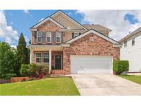 Charming two-story brick home with a well-manicured lawn, two-car garage, and inviting front porch at 3845 New Salem Ct, Cumming, GA 30040