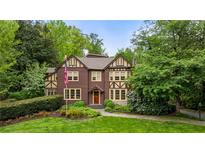 Charming Tudor home with a well-manicured lawn, mature trees, and classic architectural details at 44 Muscogee Nw Ave, Atlanta, GA 30305