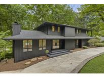Striking contemporary two-story home featuring a dark exterior and lush surroundings at 1860 Mountain Shadow, Stone Mountain, GA 30087