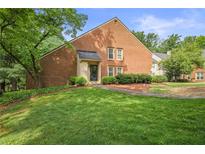 Charming brick two-story home with lush green lawn and mature trees at 2117 Bucktrout Pl, Dunwoody, GA 30338