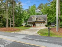 Charming two-story home featuring a covered porch, attached two-car garage, and a well-manicured front yard at 4079 Essex Dr, Villa Rica, GA 30180