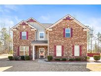 Charming two-story brick home with a well-maintained lawn and complementary trim at 12348 Hillcrest Dr, Hampton, GA 30228
