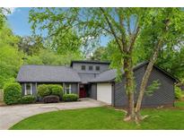 Charming home featuring a gray exterior, manicured landscaping, and a welcoming red front door at 1280 Gin House Ln, Lawrenceville, GA 30045