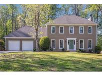 Charming two-story home with a well-manicured lawn and attached three car garage at 1627 Isham Dr, Lawrenceville, GA 30046