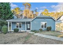 Charming single-story home with blue siding, a covered front porch, and a landscaped front yard at 3918 S Creek Ct, Stone Mountain, GA 30083