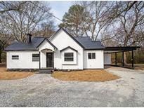 Charming renovated home featuring white siding, black roof, and inviting front entrance at 65 Sage St, Temple, GA 30179