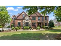 Beautiful brick home featuring manicured landscaping and stone accents on the facade at 2400 Gants Hill Pl, Cumming, GA 30041