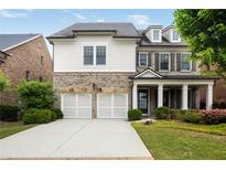 Charming two-story home featuring a brick and siding facade, a two-car garage, and a well-manicured front lawn at 4884 Kentwood Dr, Marietta, GA 30068